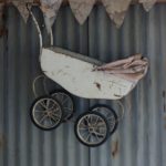 white steel baby carriage hanging from the ceiling